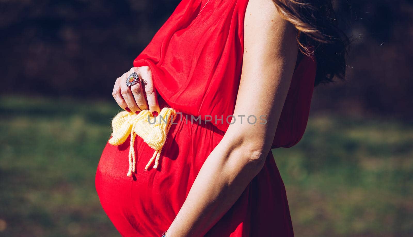 Young couple waiting for baby. Expecting parents with little baby boy shoes. Concept of Parents-To-Be. Shoes and sneakers of parents and expected baby. Mom, dad and the future baby Shoes.