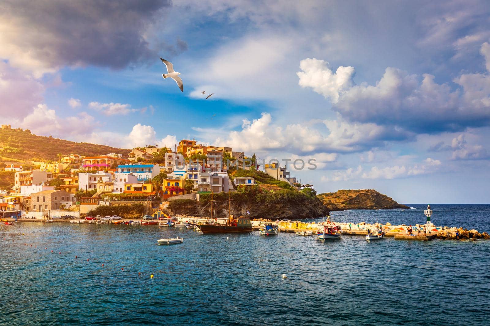 Panorama of Harbour with vessels, boats, beach and lighthouse in Bali at sunrise, Rethymno, Crete, Greece. Famous summer resort in Bali village, near Rethimno, Crete, Greece. 