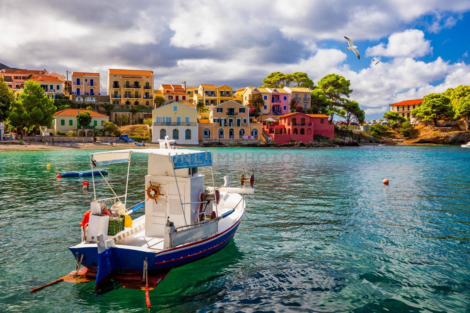 Turquoise colored bay in Mediterranean sea with beautiful colorful houses in Assos village in Kefalonia, Greece. Town of Assos with colorful houses on the mediterranean sea, Greece. 