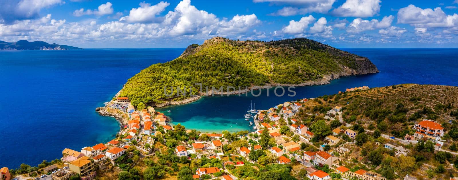Aerial drone view video of beautiful and picturesque colorful traditional fishing village of Assos in island of Cefalonia, Ionian, Greece. Peninsula of Assos in Cephalonia (Kefalonia), Greece