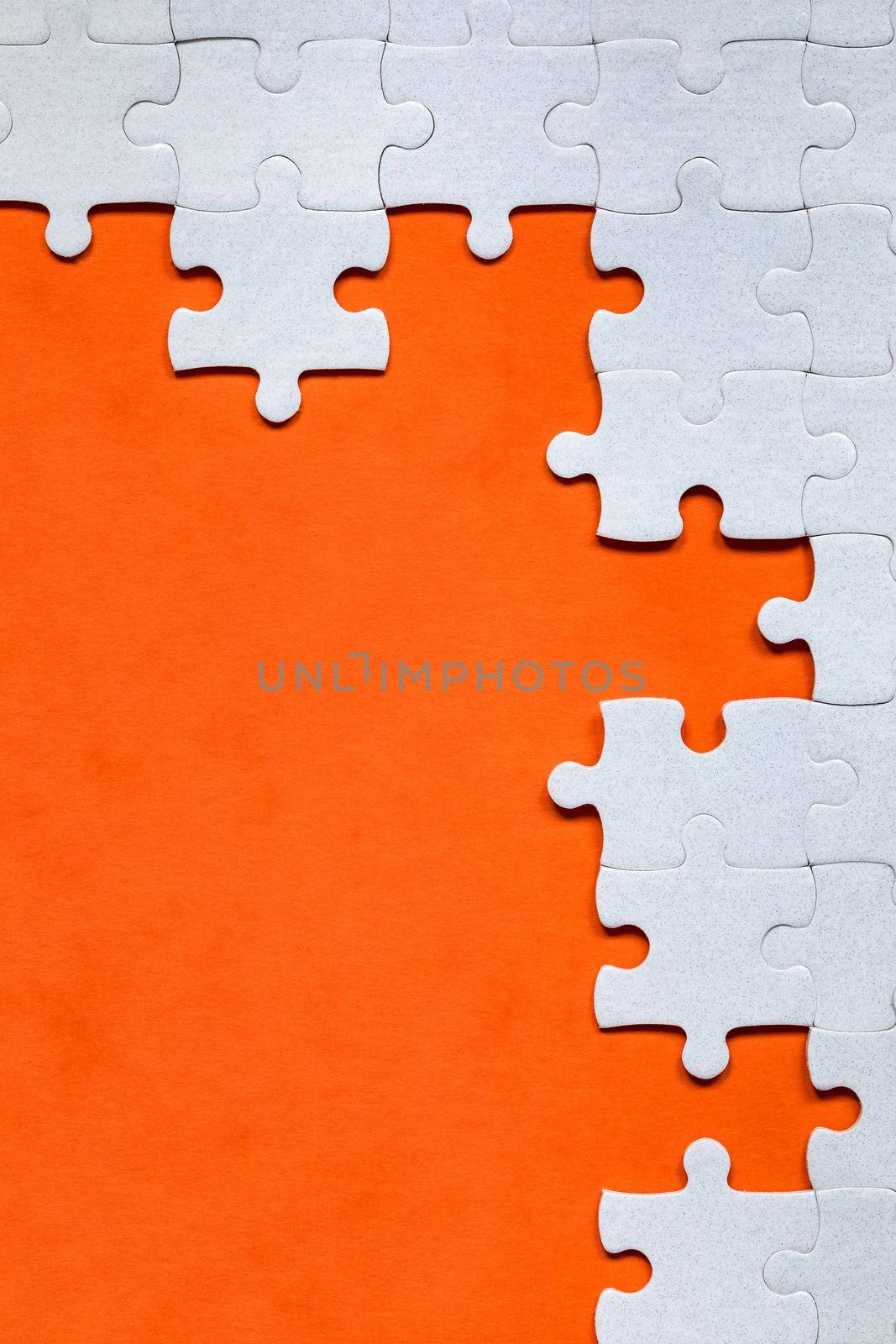 White jigsaw puzzle. White puzzle pieces on color background. Unfinished white jigsaw puzzle pieces on color background. 