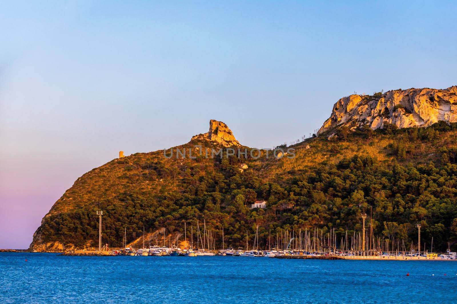 Beach of Cagliari (Poetto Sella del Diavolo) with Torre del Poetto tower and boats at sunset, Sardinia, Italy. 