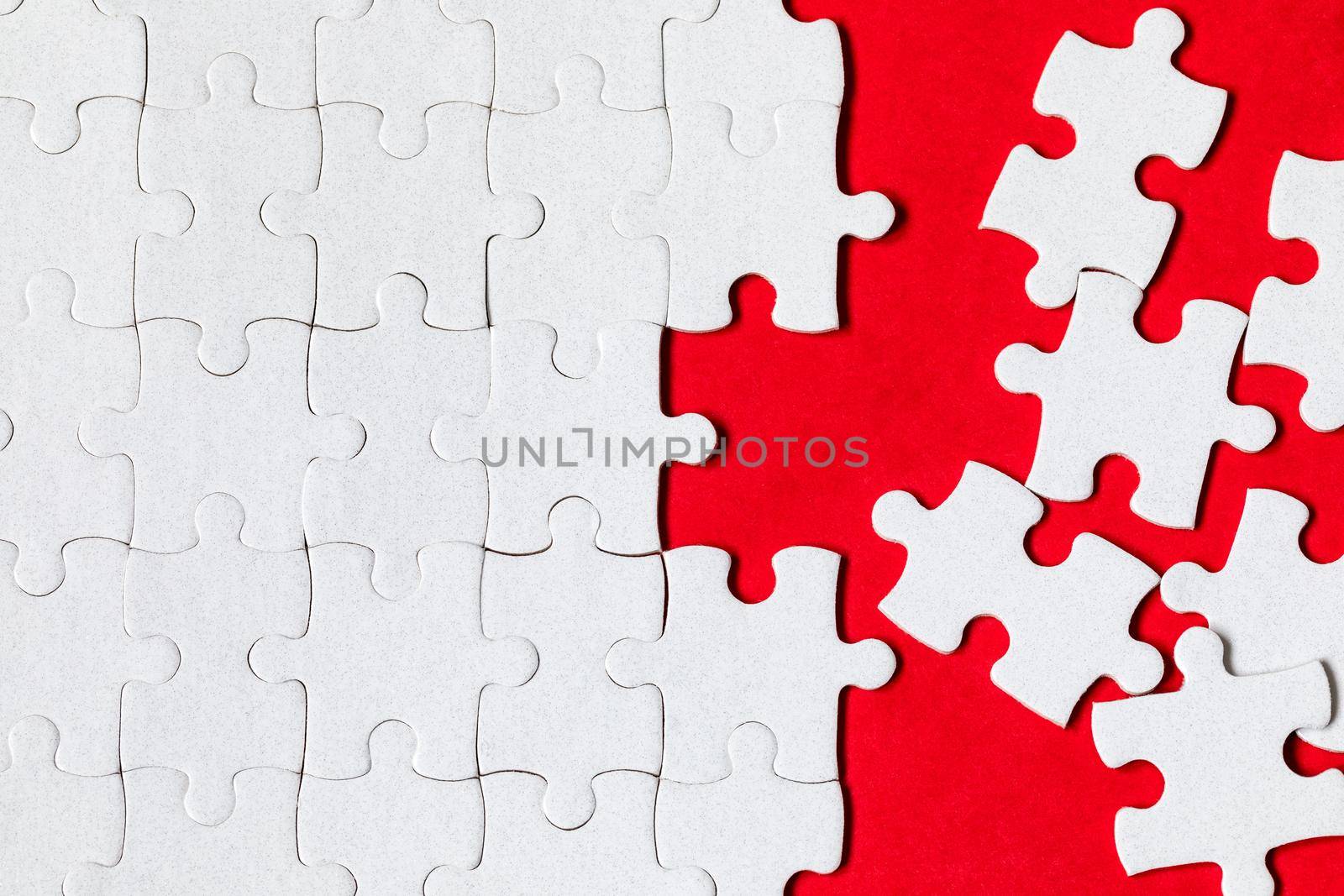 White jigsaw puzzle. White puzzle pieces on color background. Unfinished white jigsaw puzzle pieces on color background. 
