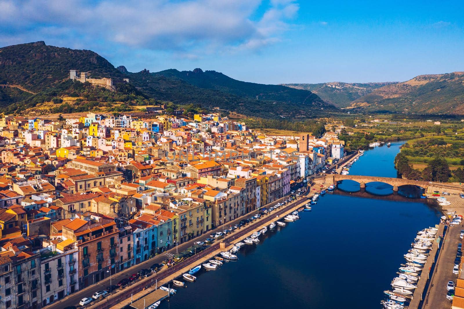 Aerial view of the beautiful village of Bosa with colored houses and a medieval castle. Bosa is located in the north-wesh of Sardinia, Italy. Aerial view of colorful houses in Bosa village, Sardegna.