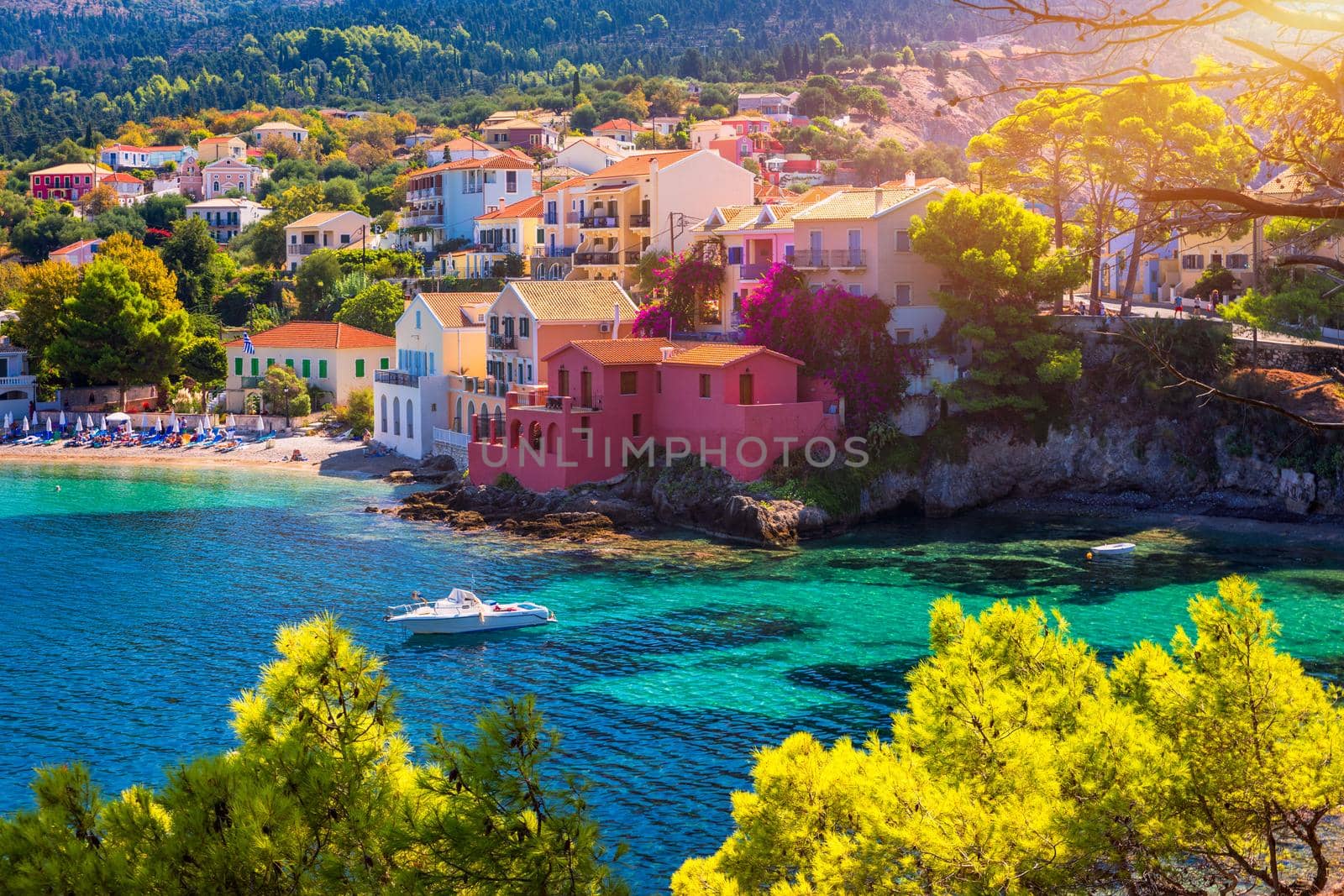Turquoise colored bay in Mediterranean sea with beautiful colorful houses in Assos village in Kefalonia, Greece. Town of Assos with colorful houses on the mediterranean sea, Greece. 