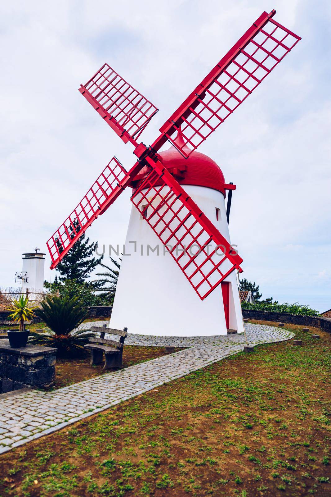 Old windmill Red Peak Mill in Bretanha (Sao Miguel, Azores). Traditional white wind mill with red roof and wings in village Bretanha, Sao Miguel Island, Azores, Portugal. 