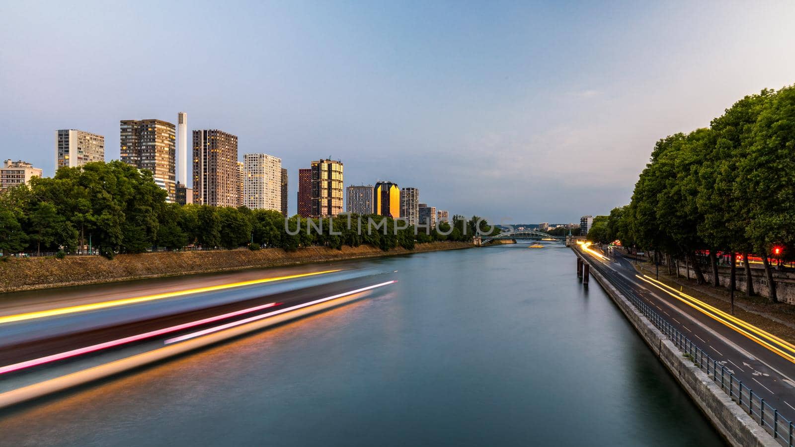 Towers and skyscrapers in Paris, France, used as office buildings as well as office buildings, by the water in front of barges on the river Seine in Quai de Grenelle, Front-de-Seine District. Paris
