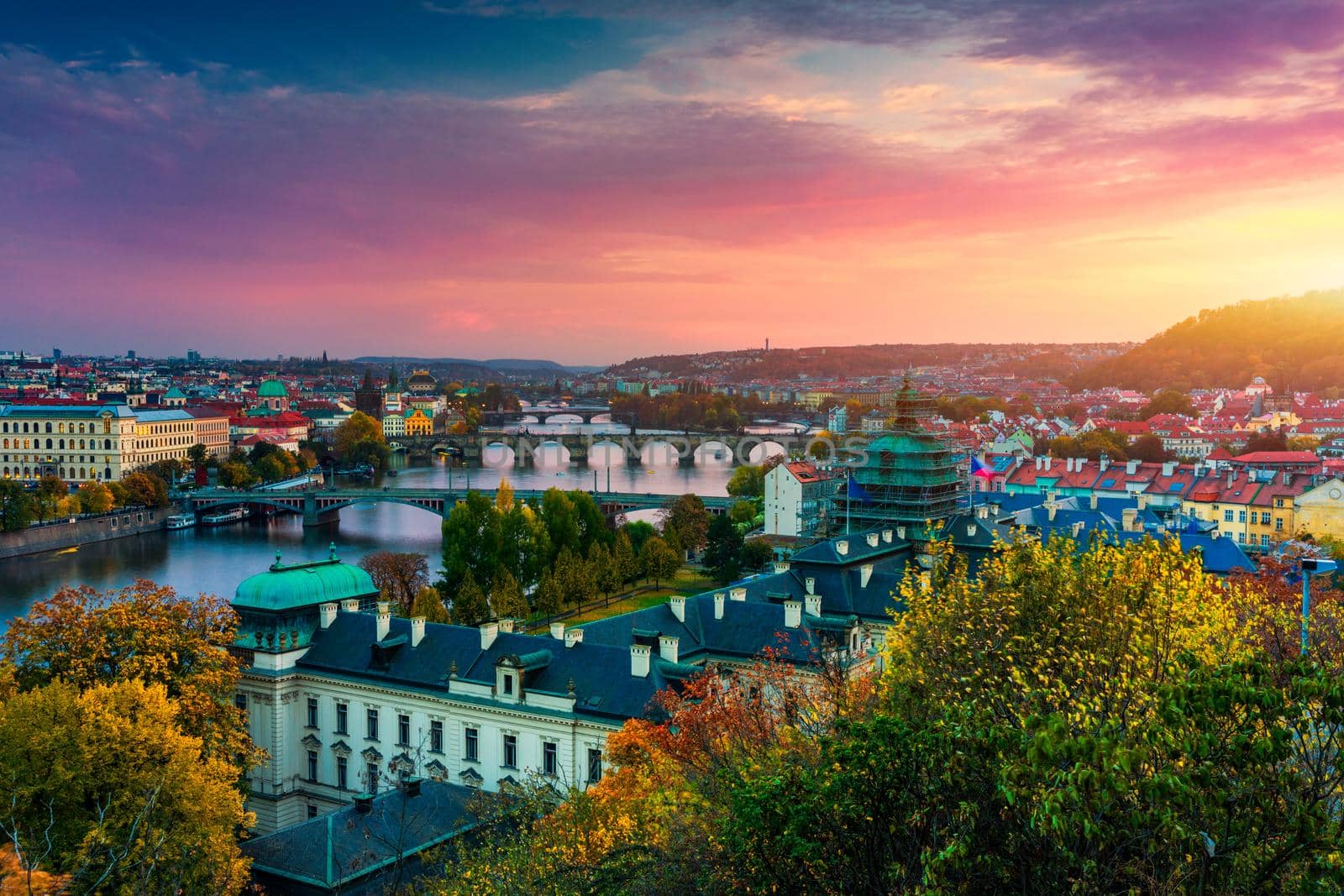 Autumn view to Charles bridge on Vltava river in Prague, Czech Republic. Autumn view to Charles Bridge, Prague old town and Vltava river from Letna park (Letenske sady) at sunset with colorful sky.