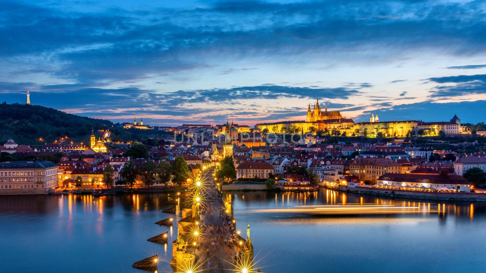 Prague Castle, Charles Bridge and boats on the Vltava river. View of Hradcany Prague Castle, Charles Bridge and a boats on the Vltava river in the capital of the Czechia. Boat cruise on Vltava river.