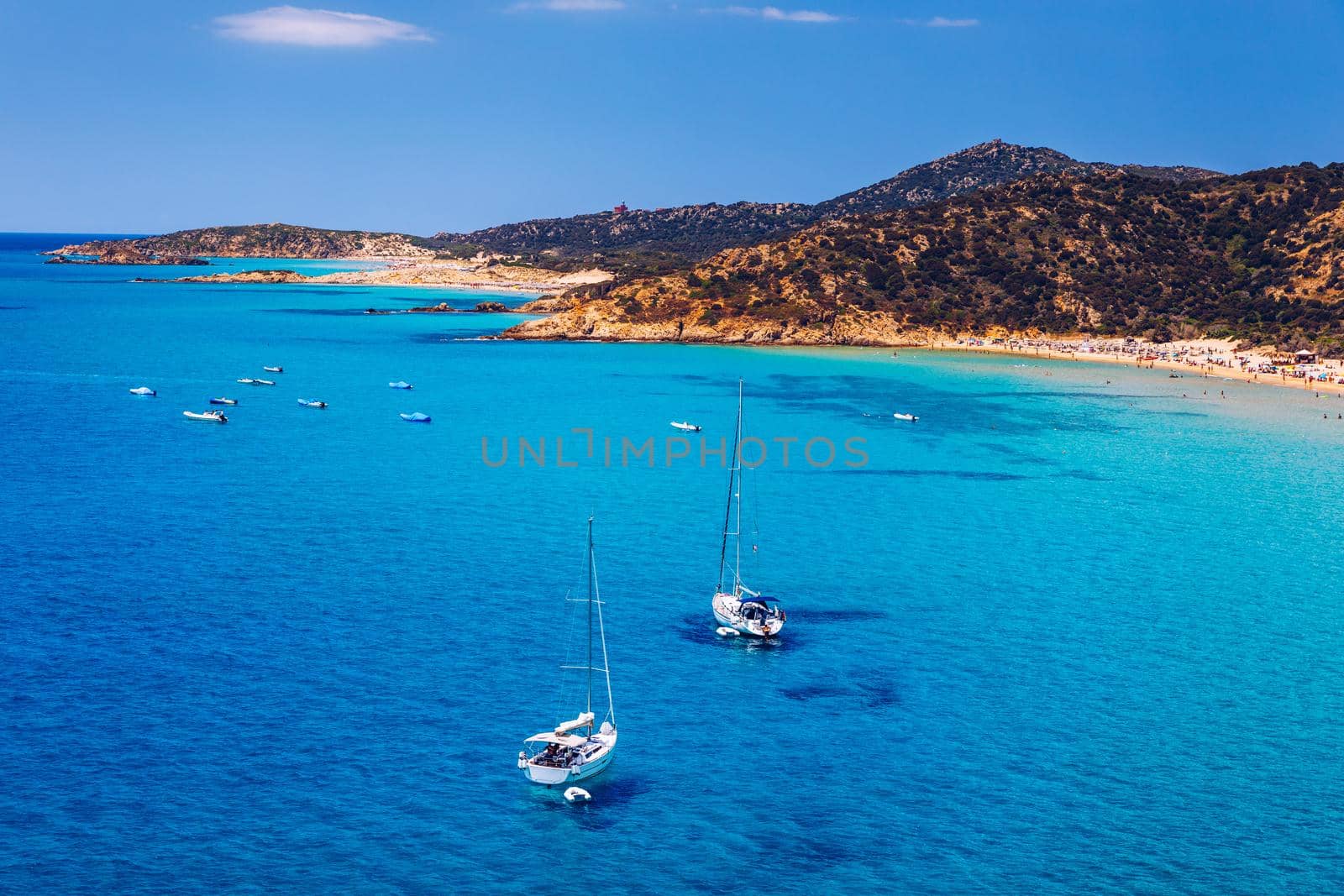 Aerial view of anchored sailing yacht in emerald sea. Aerial view of a boat. Outdoor water sports, yachting. Aerial view of anchoring yacht in open water. Ocean and sea travel and transportation