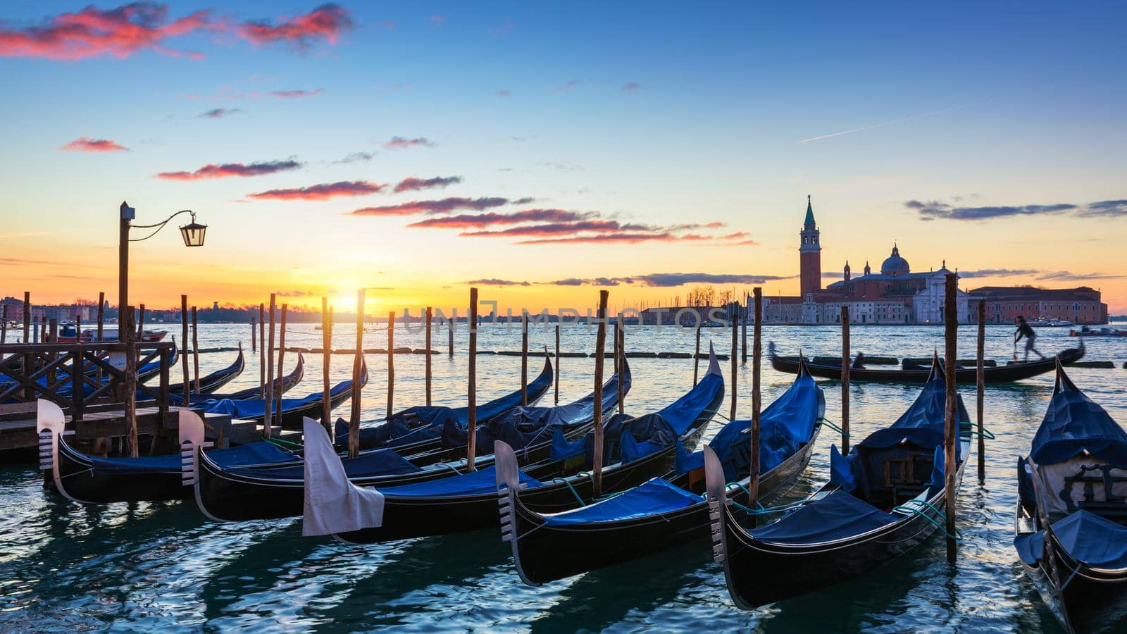 Scenic view of San Giorgio Maggiore, gondolas and lamp at colorful sunrise, Venice, Italy. Sunset in Venice. Gondolas at Saint Mark's Square and church of San Giorgio Maggiore on background, Italy, Europe