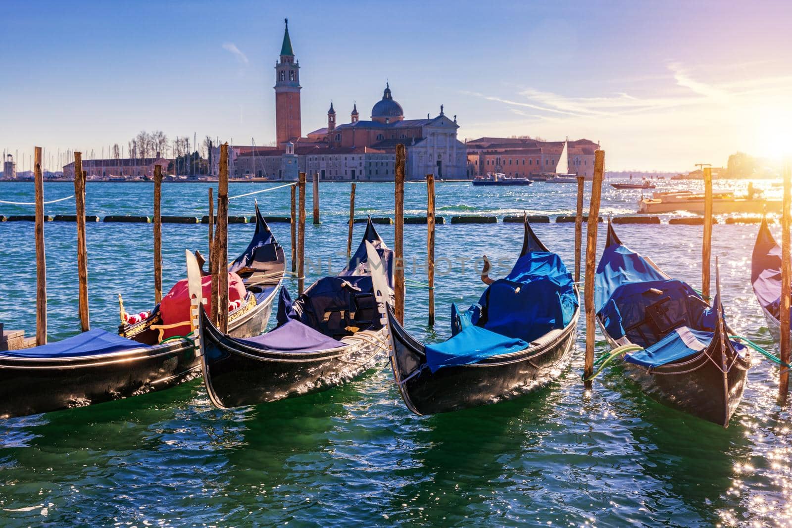 Gondolas moored near San Marco square across from San Giorgio Maggiore island in Venice, Italy. Gondolas were once the main form of transportation around the Venetian canals. Venice, Italy.