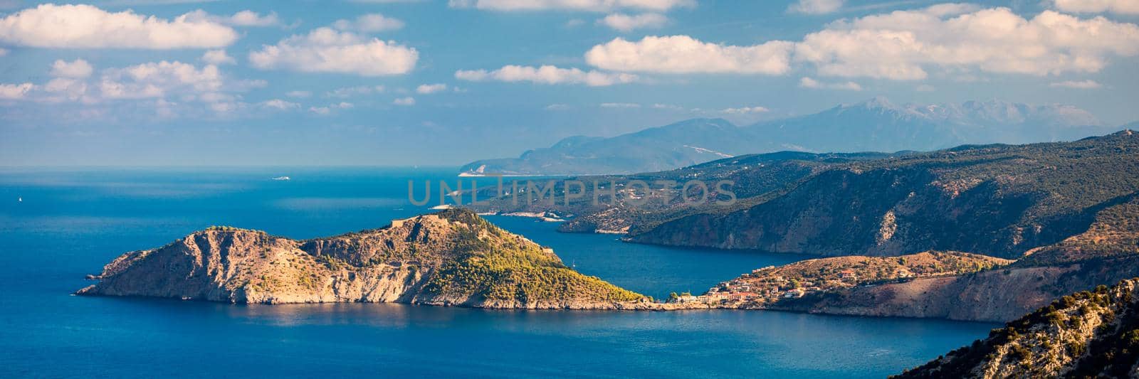 Assos village in Kefalonia, Greece. Turquoise colored bay in Mediterranean sea with beautiful colorful houses in Assos village in Kefalonia, Greece, Ionian island, Cephalonia, Assos village.