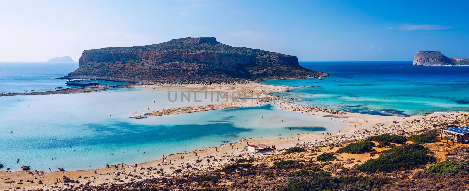 Fantastic panorama of Balos Lagoon and Gramvousa island on Crete, Greece. Cap tigani in the center. Balos beach on Crete island, Greece. Tourists relax and bath in crystal clear water of Balos beach.