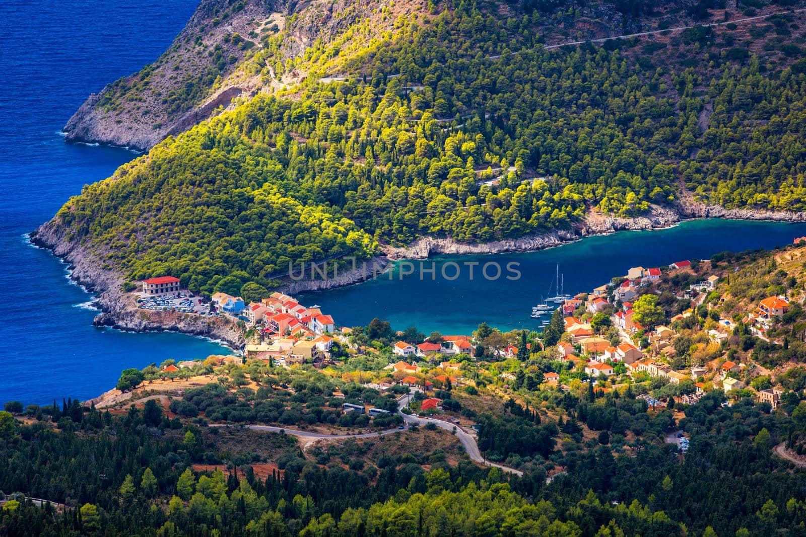 Assos village in Kefalonia, Greece. Turquoise colored bay in Mediterranean sea with beautiful colorful houses in Assos village in Kefalonia, Greece, Ionian island, Cephalonia, Assos village.