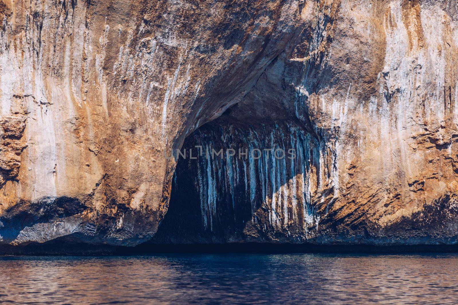 Blue sea and the characteristic caves of Cala Luna, a beach in the Golfo di Orosei, Sardinia, Italy. Big sea caves in the mediterranean coast. Sardinia, Italy.