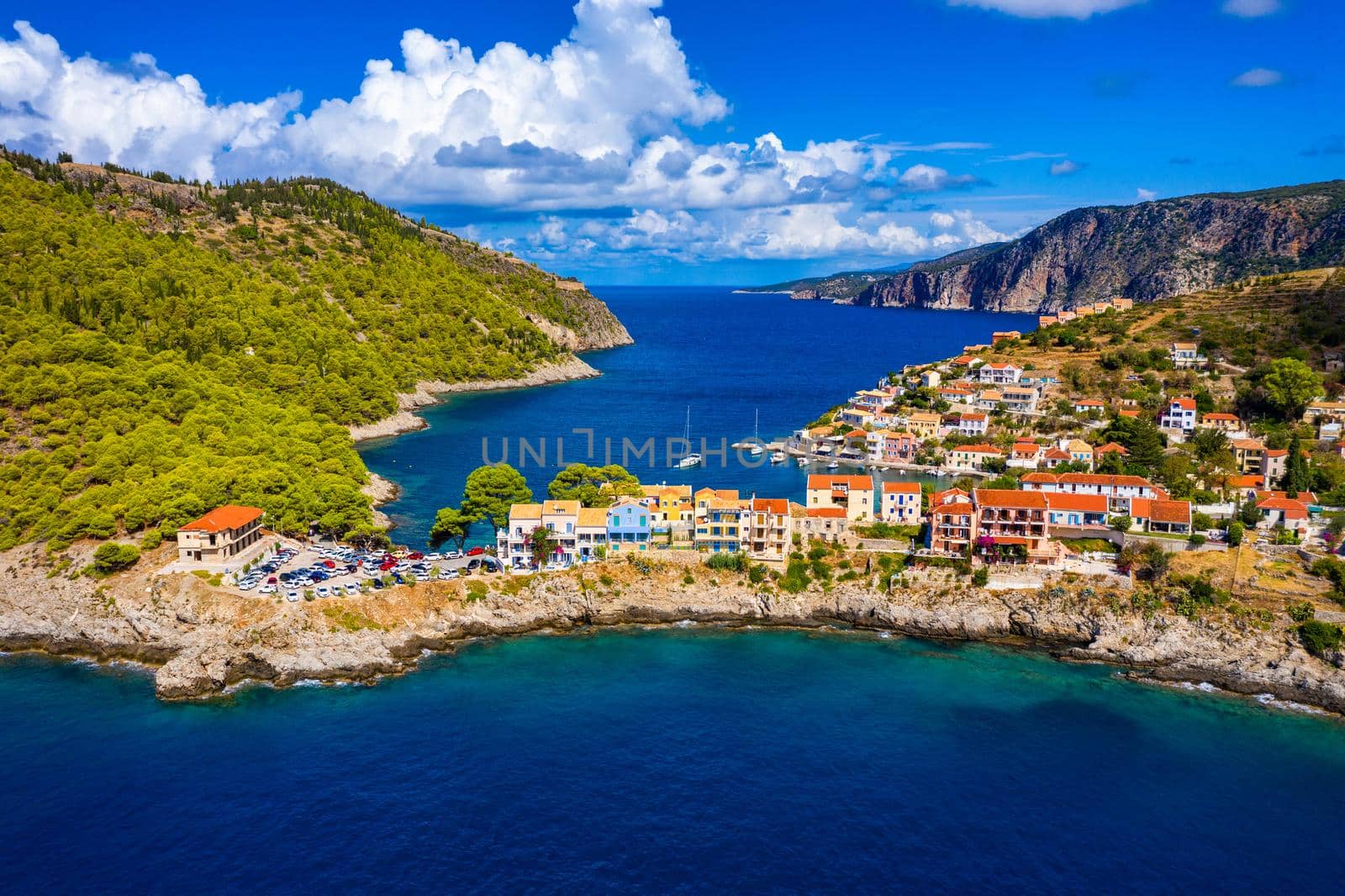 Turquoise colored bay in Mediterranean sea with beautiful colorful houses in Assos village in Kefalonia, Greece. Town of Assos with colorful houses on the mediterranean sea, Greece. 
