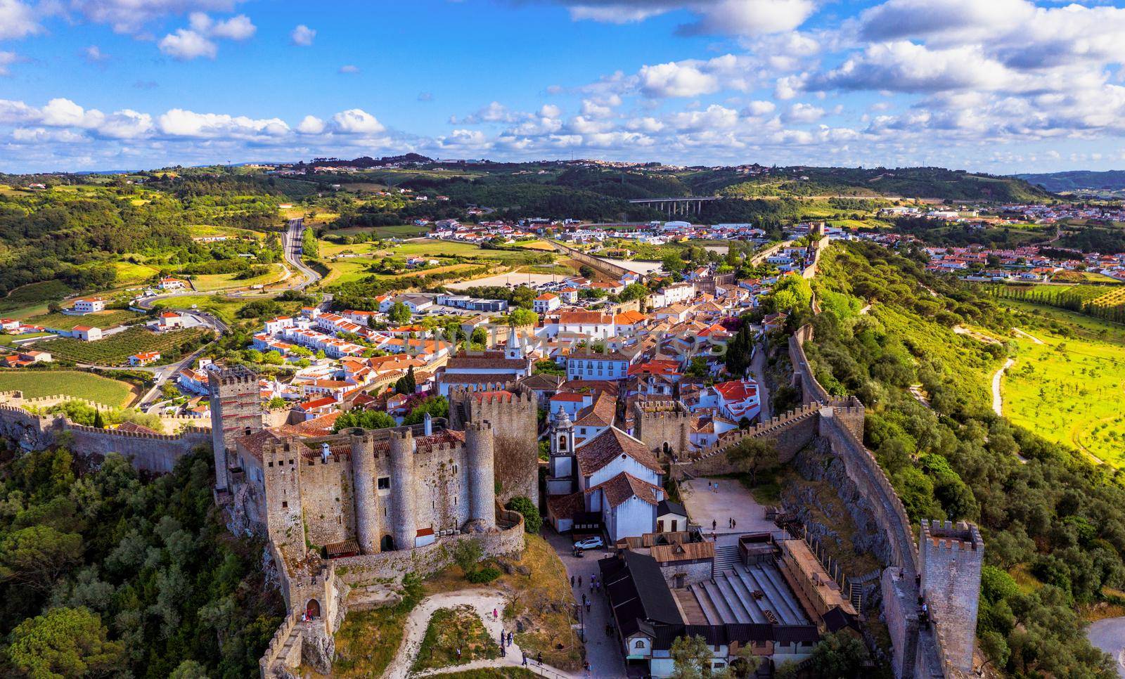 Aerial view of the historic walled town of Obidos at sunset, near Lisbon, Portugal. Aerial shot of Obidos Medieval Town, Portugal. Aerial view of medieval fortress in Obidos. Portugal.