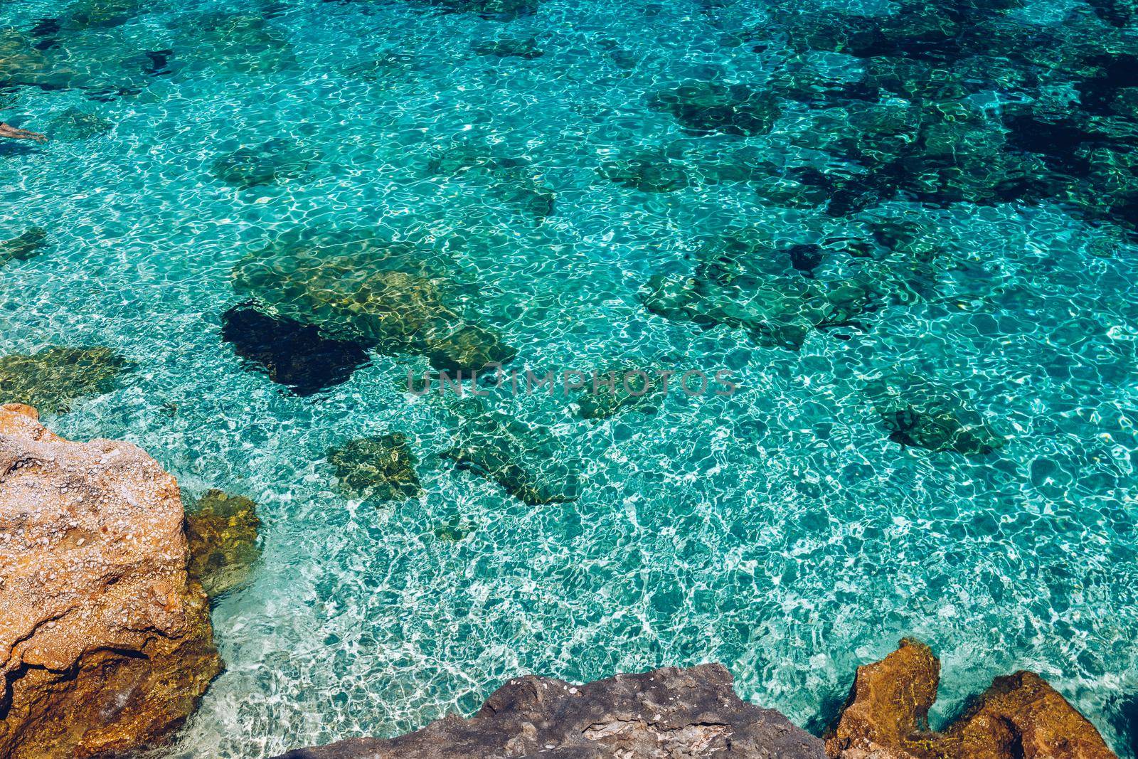 Water surface with bright sun light reflections, sea water background. Background of transparent sea water. Blue ripped sea water background.