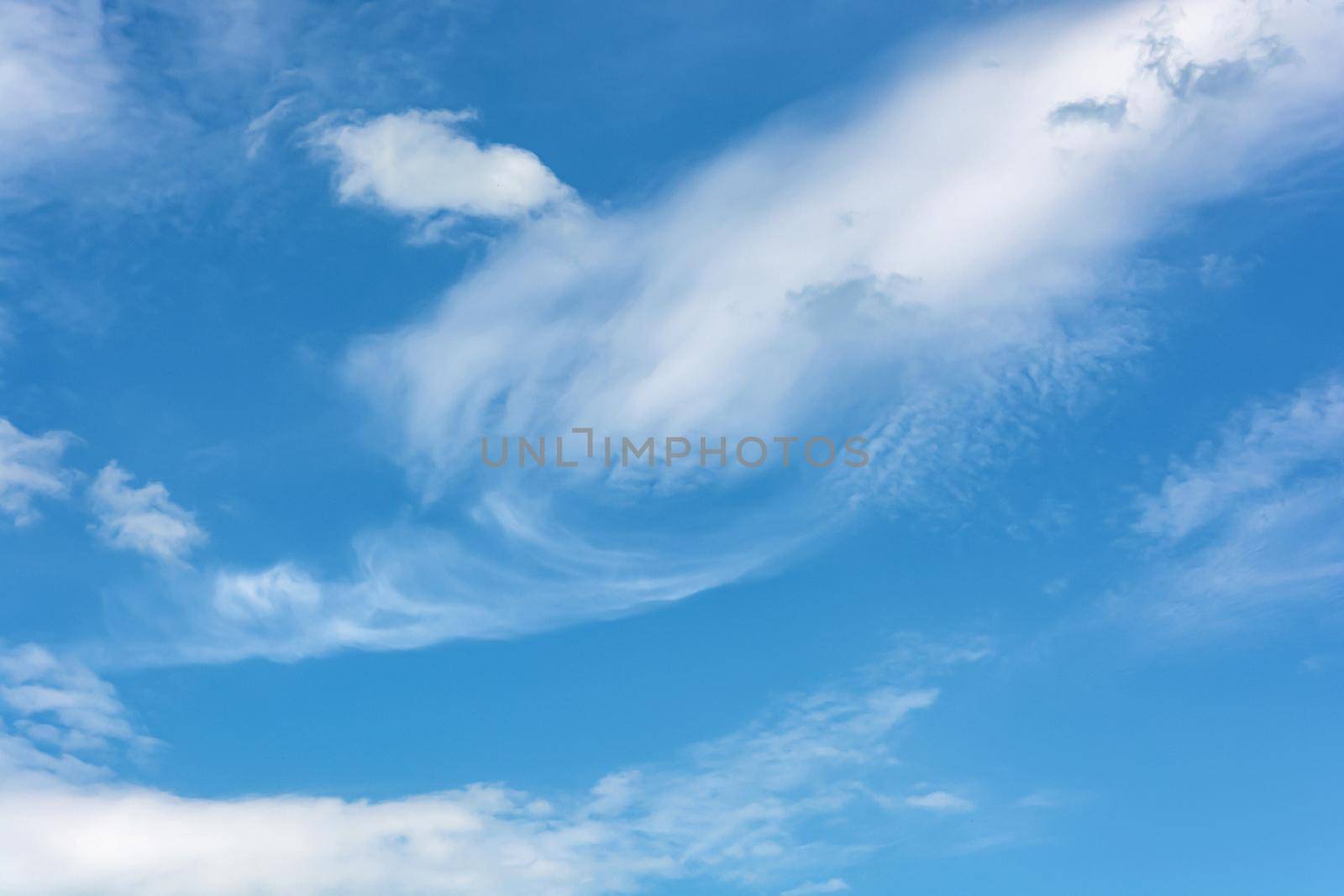White cirrus clouds against the blue sky. Close-up, blurred, background. Stock photography.