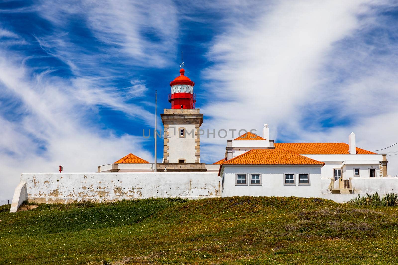 The lighthouse in Cabo da Roca. Cliffs and rocks on the Atlantic ocean coast in Sintra in a beautiful summer day, Portugal. Cabo da Roca, Portugal. Lighthouse and cliffs over Atlantic Ocean.