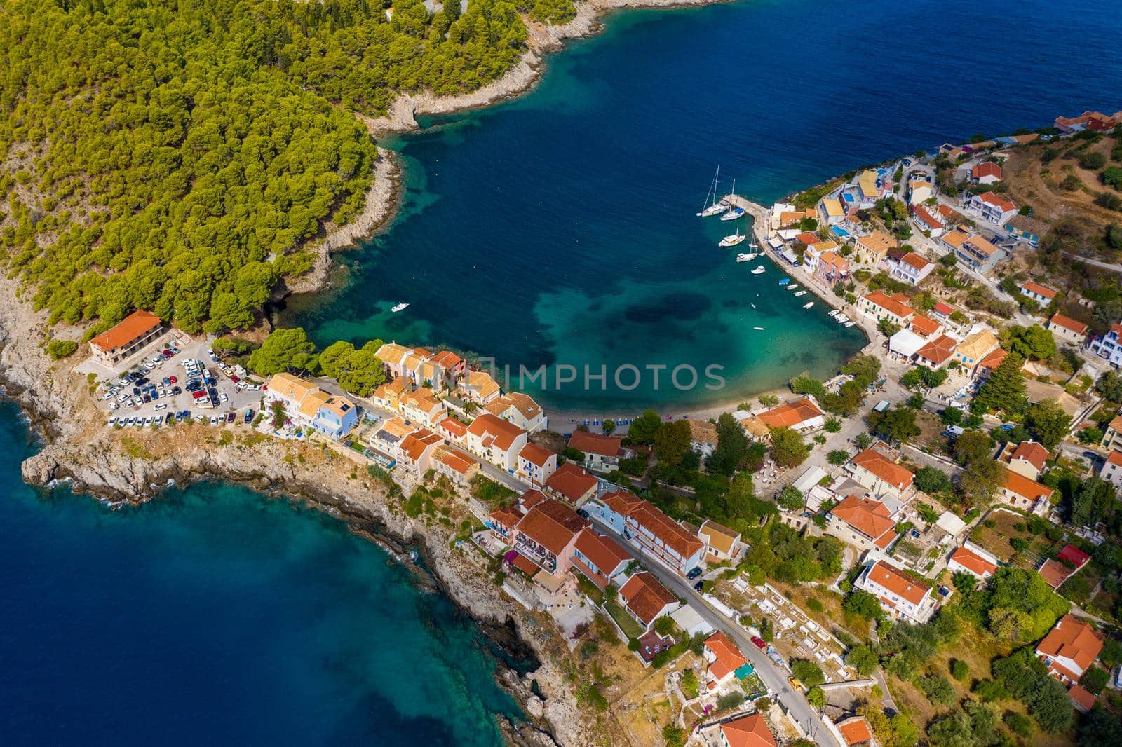 Aerial drone view video of beautiful and picturesque colorful traditional fishing village of Assos in island of Cefalonia, Ionian, Greece. Peninsula of Assos in Cephalonia (Kefalonia), Greece