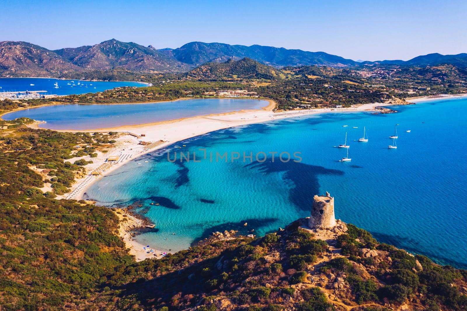 Torre di Porto Giunco Tower and Simius Beach near Villasimius, Sardinia, Italy. View from flying drone. Torre di Porto Giunco tower on Carbonara cape. Aerial morning view of Sardinia island, Italy