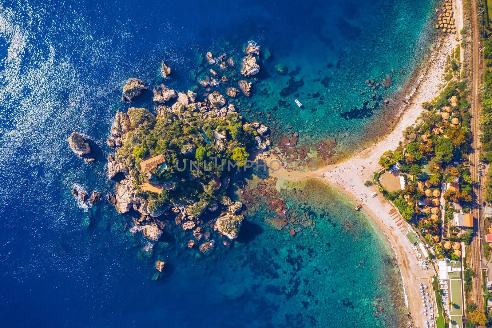 Aerial view of Isola Bella in Taormina, Sicily, Italy. Isola Bella is small island near Taormina, Sicily, Italy. Narrow path connects island to mainland Taormina beach in azure waters of Ionian Sea. 