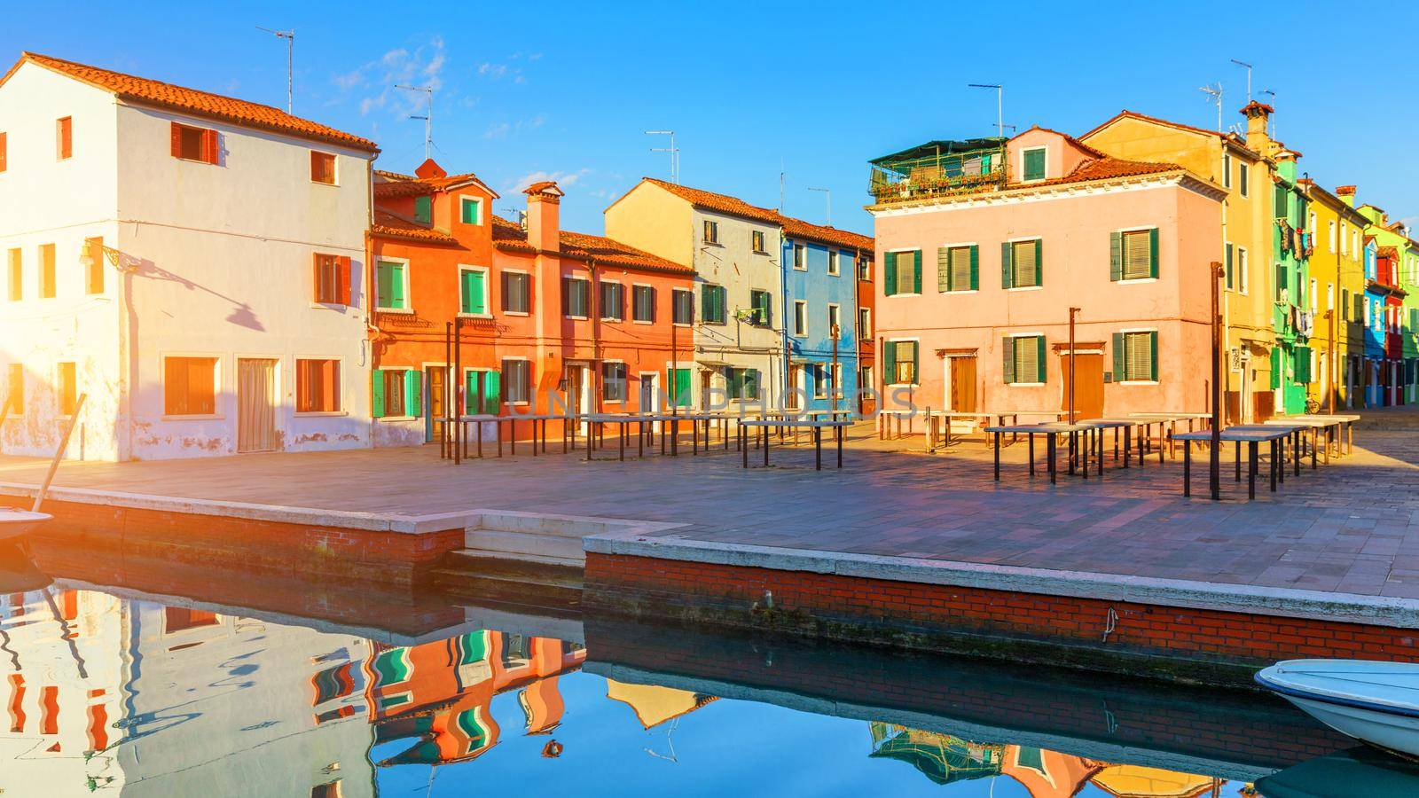 Street with colorful buildings in Burano island, Venice, Italy. Architecture and landmarks of Burano, Venice postcard. Scenic canal and colorful architecture in Burano island near Venice, Italy