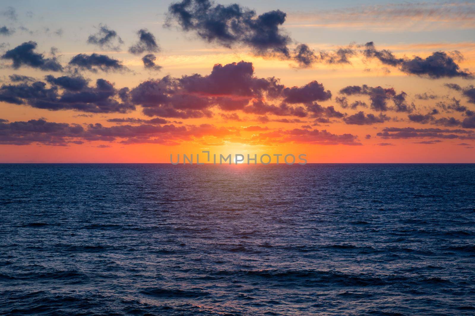 Beautiful sunset/sunrise over the sea. Beautiful sunset over the ocean. Beautiful sunset over sea with reflection in water, majestic clouds in the sky