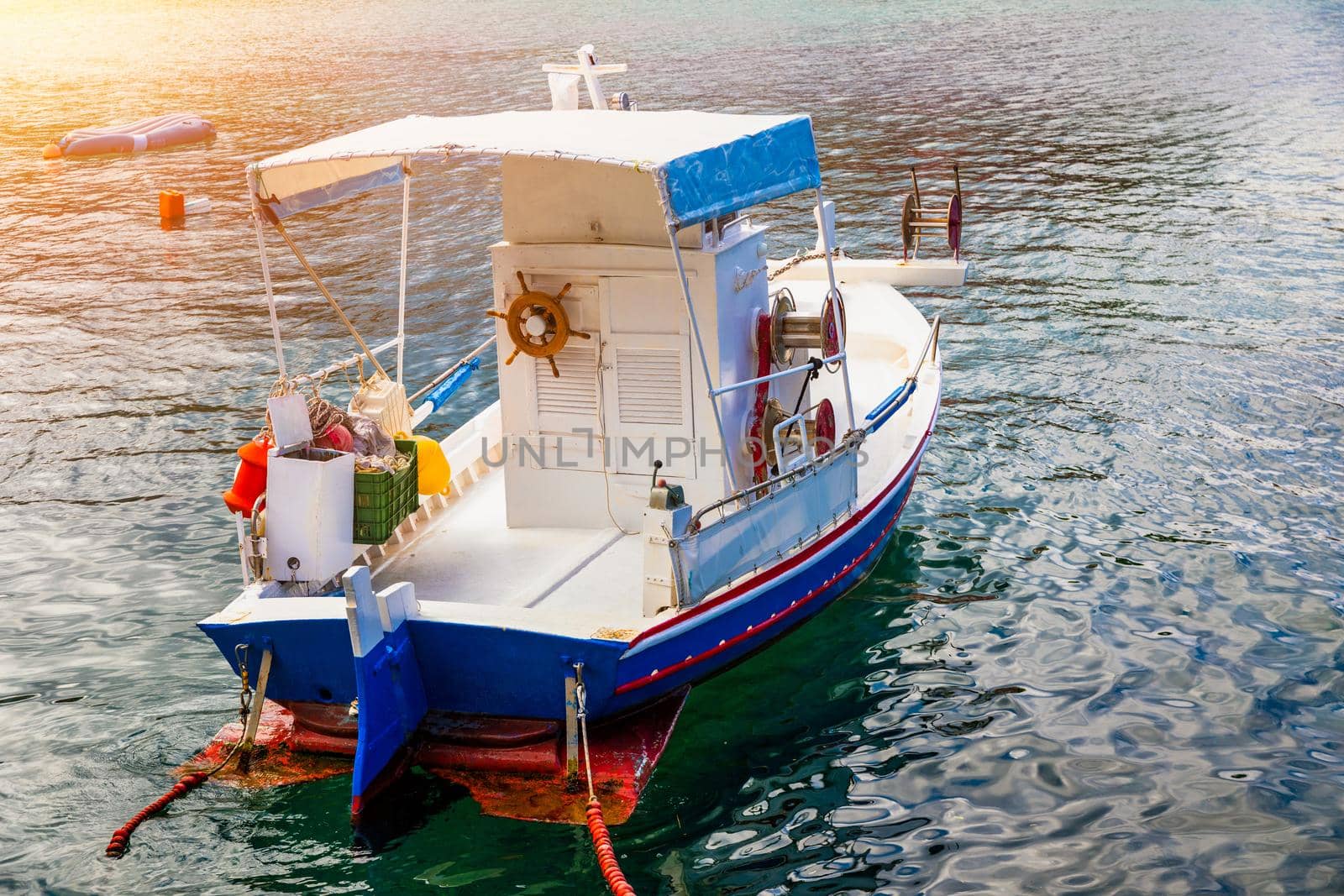 Vintage wooden boat in coral sea. Boat drone photo. Fishing boats in clear turquoise ocean, top view. Small fishing boat moored in blue clean transparent water. Aerial view. Peniche, Portugal.