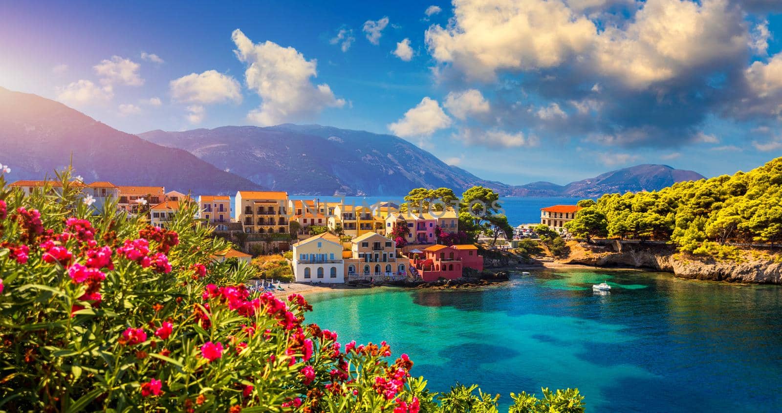 Assos village in Kefalonia, Greece. Turquoise colored bay in Mediterranean sea with beautiful colorful houses in Assos village in Kefalonia, Greece, Ionian island, Cephalonia, Assos village.