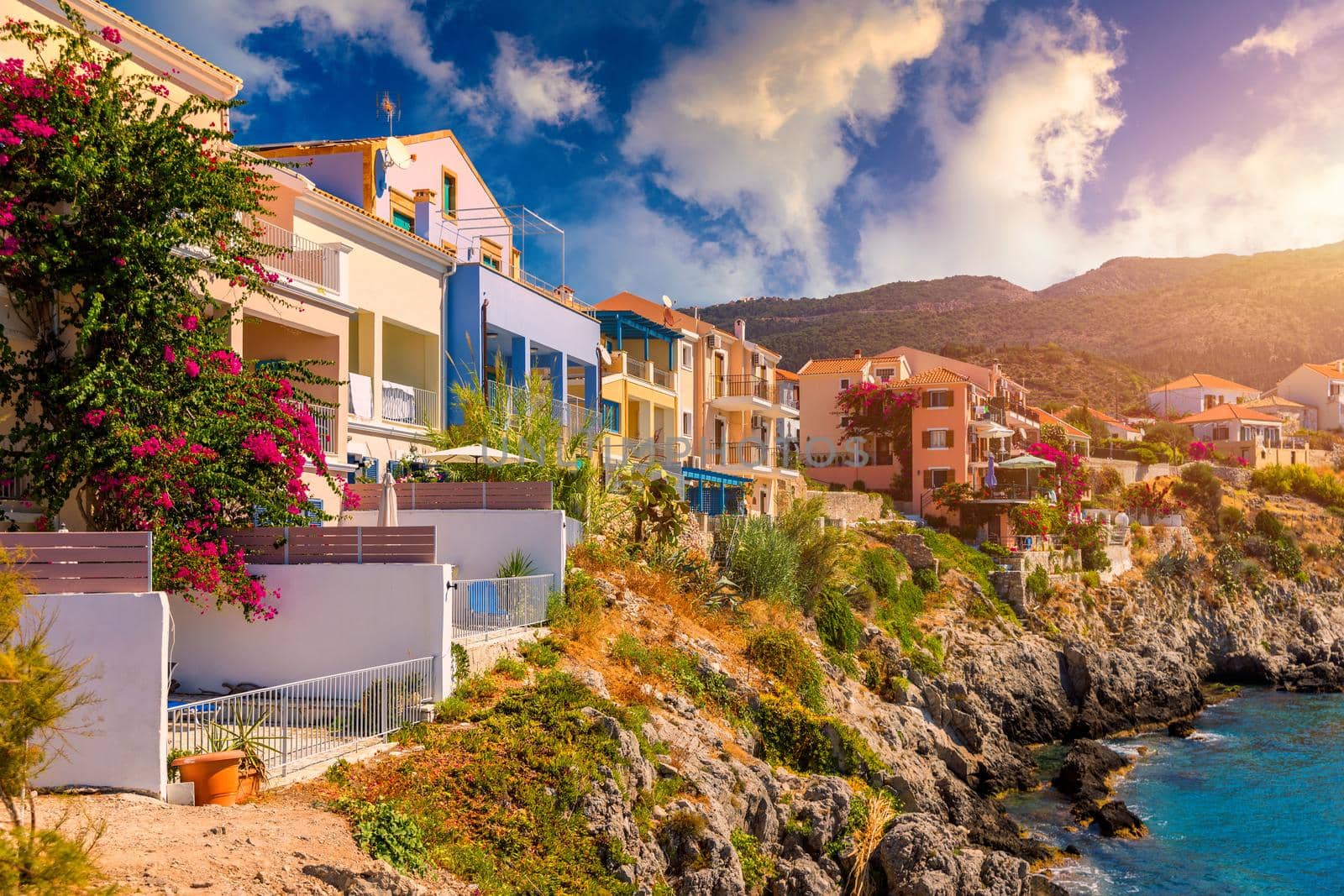 Assos village in Kefalonia, Greece. Turquoise colored bay in Mediterranean sea with beautiful colorful houses in Assos village in Kefalonia, Greece, Ionian island, Cephalonia, Assos village.
