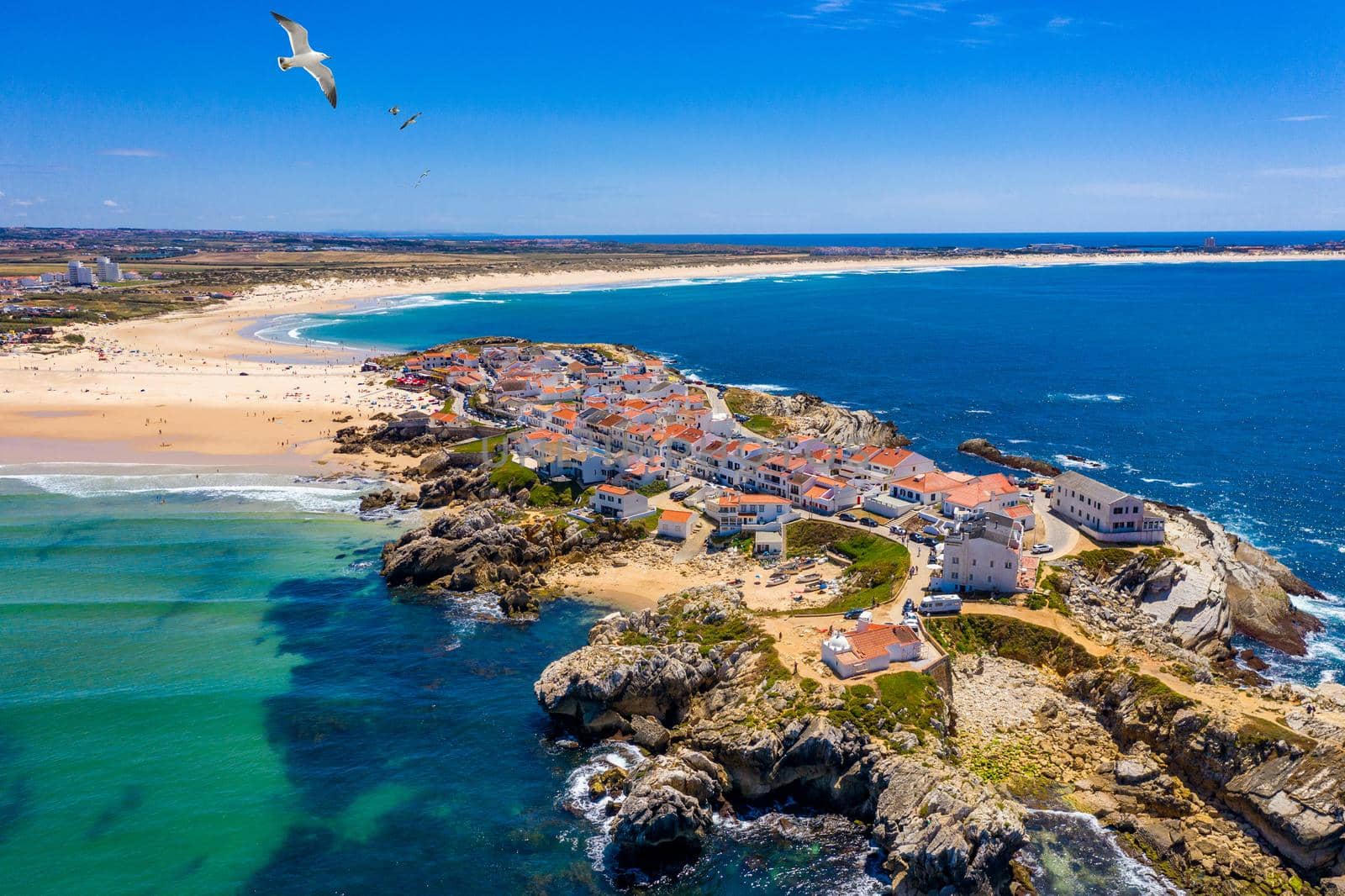Aerial view of island Baleal naer Peniche on the shore of the ocean in west coast of Portugal. Baleal Portugal with incredible beach and surfers. Aerial view of Baleal, Portugal.