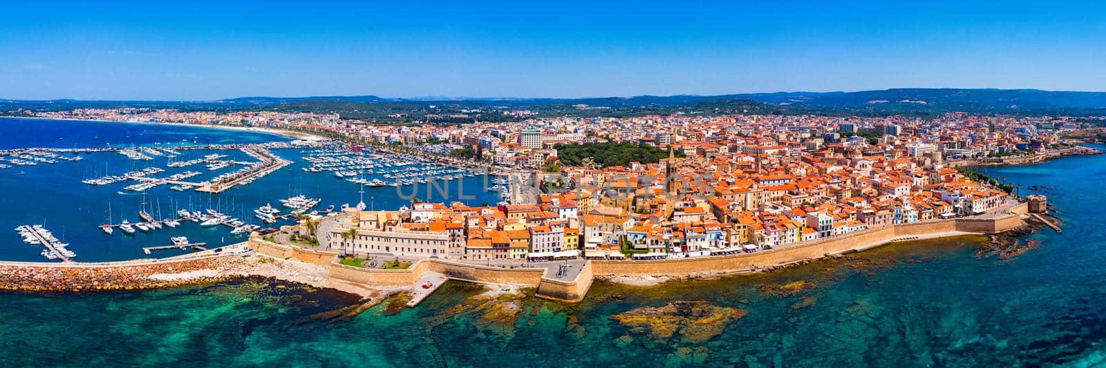 Aerial view over Alghero old town, cityscape Alghero view on a beautiful day with harbor and open sea in view. Alghero, Italy. Panoramic aerial view of Alghero, Sardinia, Italy. 