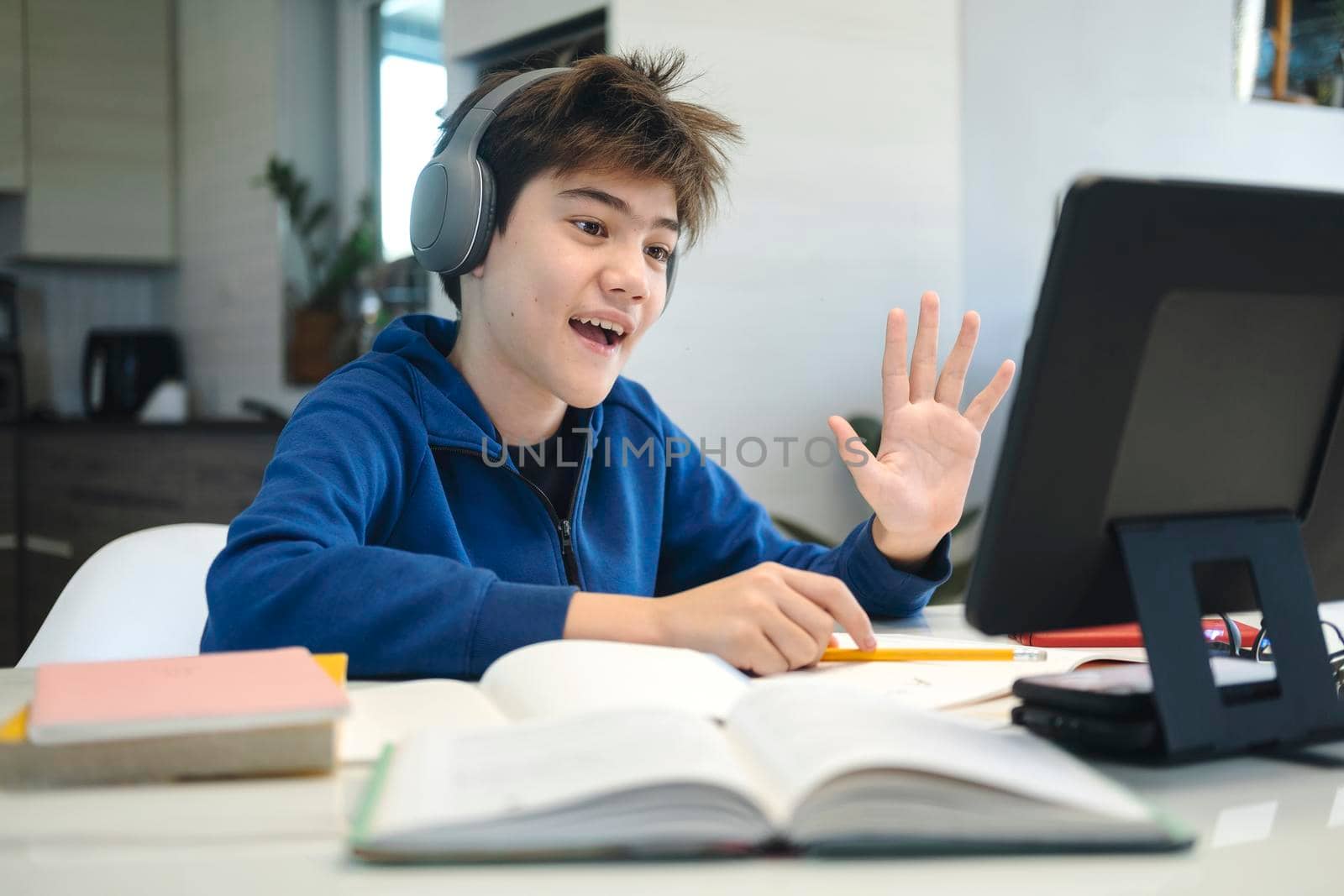 Young boy using computer and mobile device studying online. Education and online learning. 