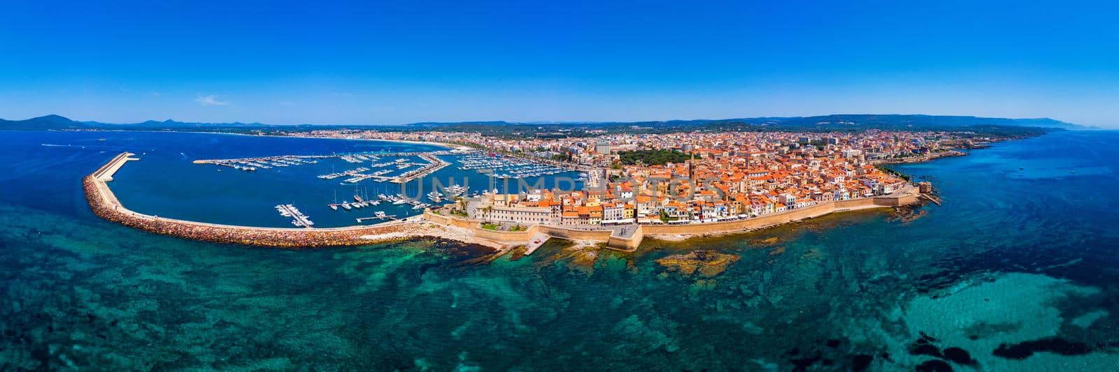 Aerial view over Alghero old town, cityscape Alghero view on a beautiful day with harbor and open sea in view. Alghero, Italy. Panoramic aerial view of Alghero, Sardinia, Italy. 