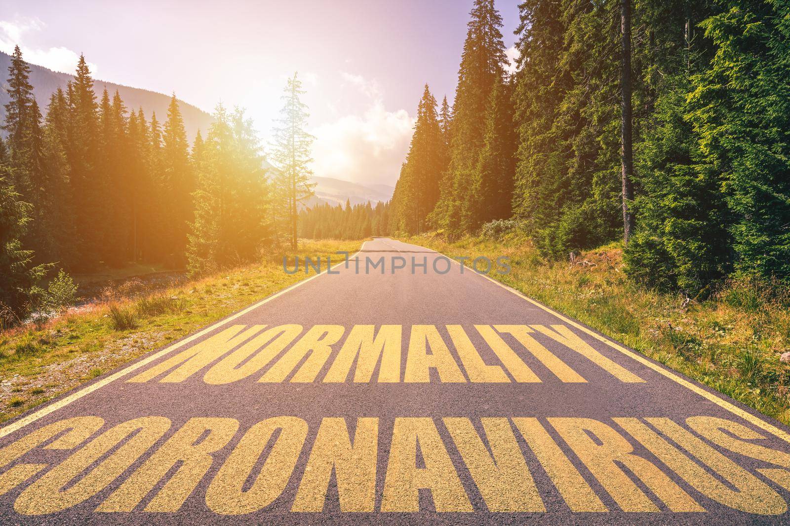 Driving on the road in the mountains to the New Normal (Normality) and leaving behind Covid-19 (Coronavirus). Covid-19 (Coronavirus) written on the asphalt road and New Normal or Normality concept. 