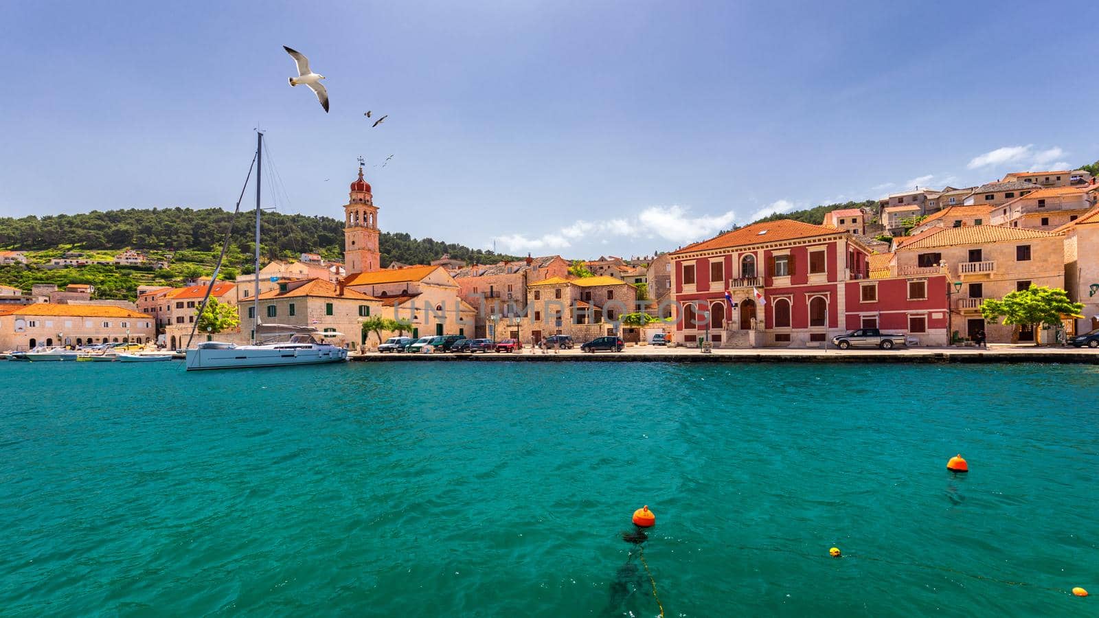 Panorama of picturesque town Pucisca in Croatia, Island Brac, Europe. Pucisca town mediterranean panorama with seagull's flying over the town. Croatia, Island Brac, Europe.