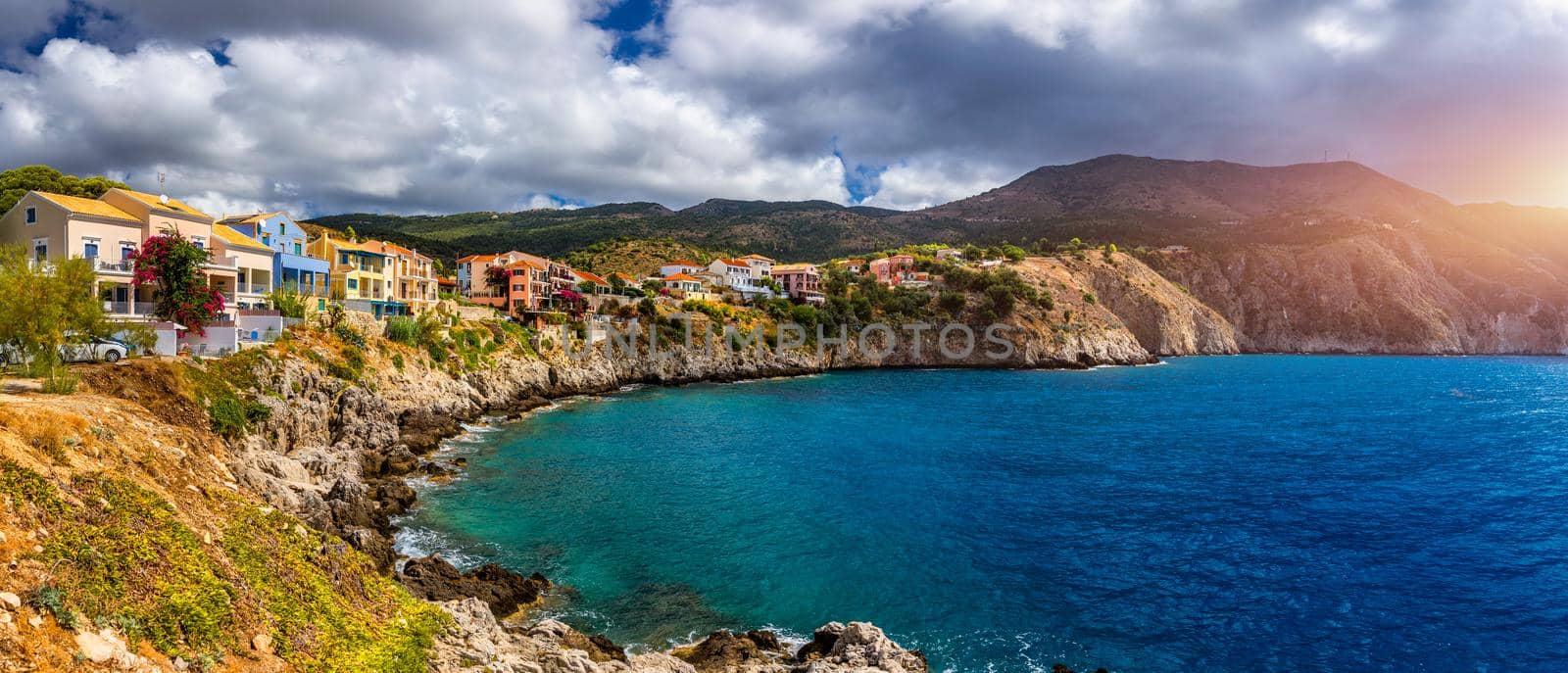 Assos village in Kefalonia, Greece. Turquoise colored bay in Mediterranean sea with beautiful colorful houses in Assos village in Kefalonia, Greece, Ionian island, Cephalonia, Assos village.