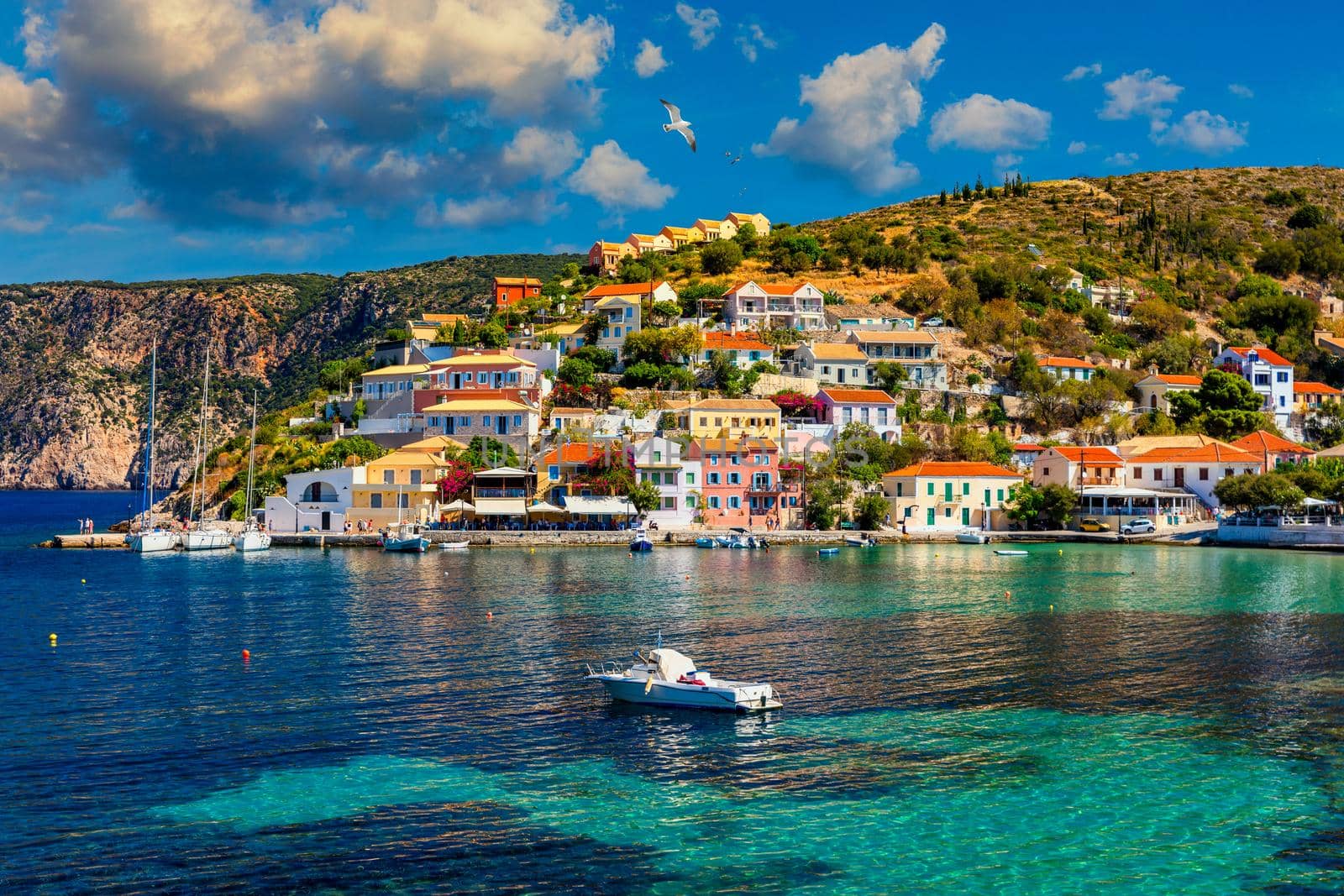 Assos village in Kefalonia, Greece. Turquoise colored bay in Mediterranean sea with beautiful colorful houses in Assos village in Kefalonia, Greece, Ionian island, Cephalonia, Assos village.