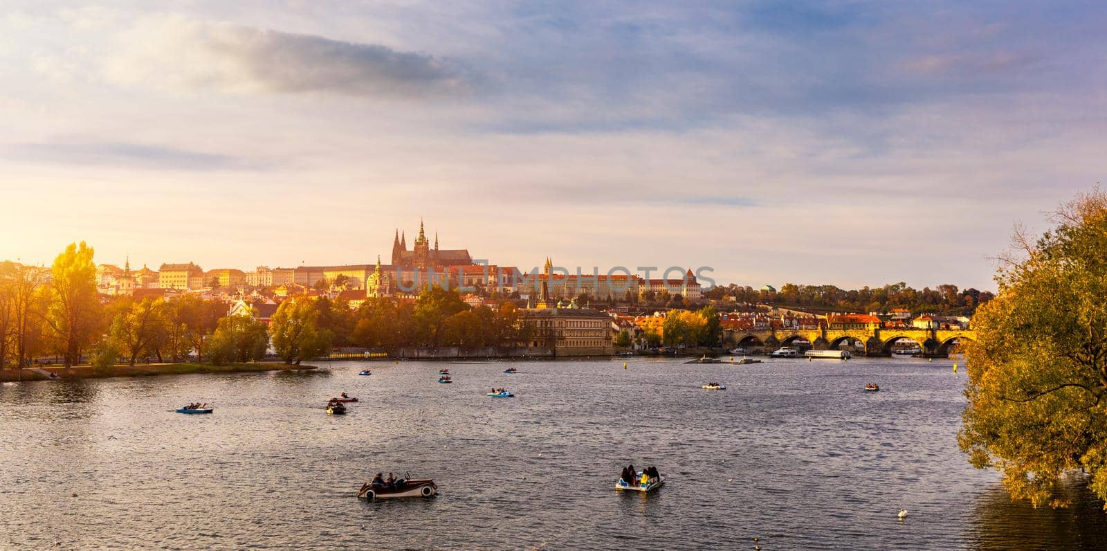 Autumn view to Charles bridge on Vltava river in Prague, Czech Republic. Autumn view to Charles Bridge, Prague old town and Vltava river. Czechia. Scenic autumn view of the Old Town with red foliage.