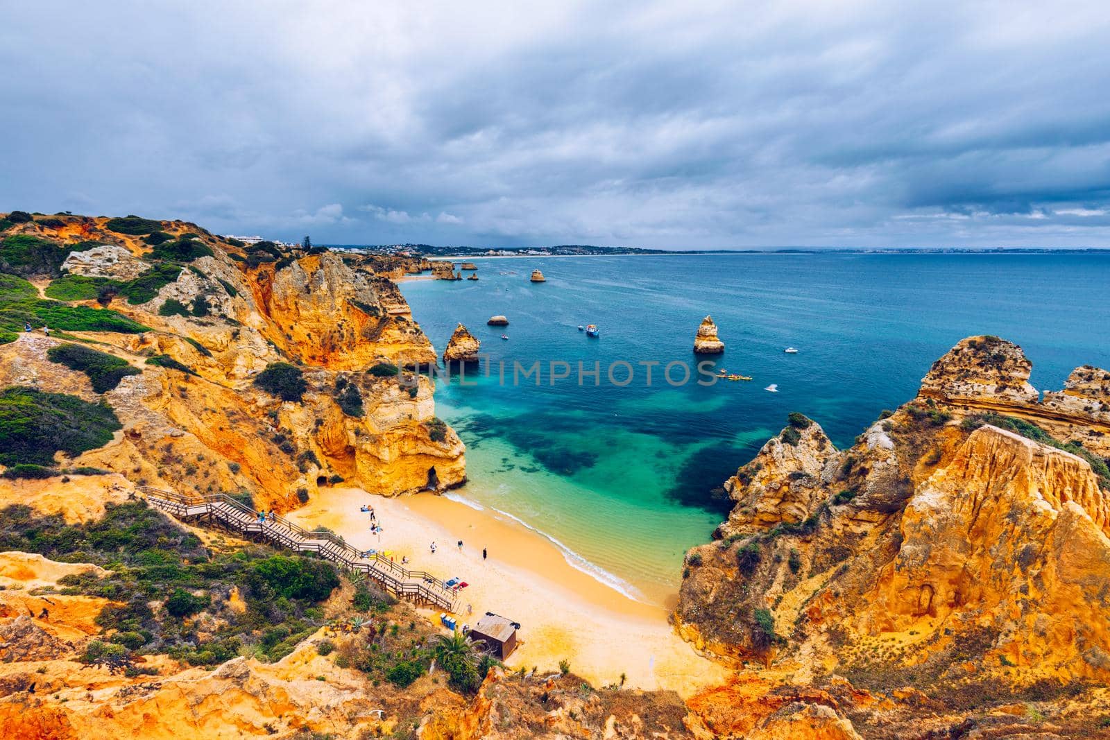 Camilo beach (Praia do Camilo) in Lagos, Algarve, Portugal. Wooden footbridge to the beach Praia do Camilo, Portugal. Picturesque view of Praia do Camilo beach in Lagos, Algarve region, Portugal.