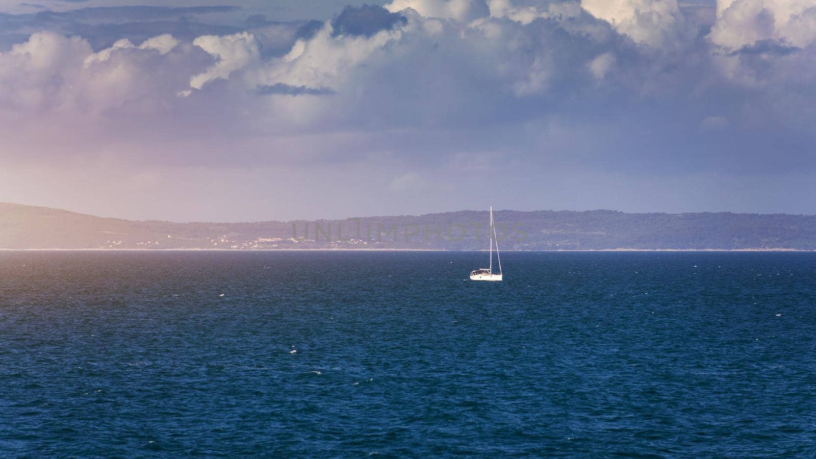 Sailboat in the sea in the evening sunlight with mountains background, luxury summer adventure, active vacation in Mediterranean sea, Croatia. Sailing ship luxury yacht with white sails in the Sea. 