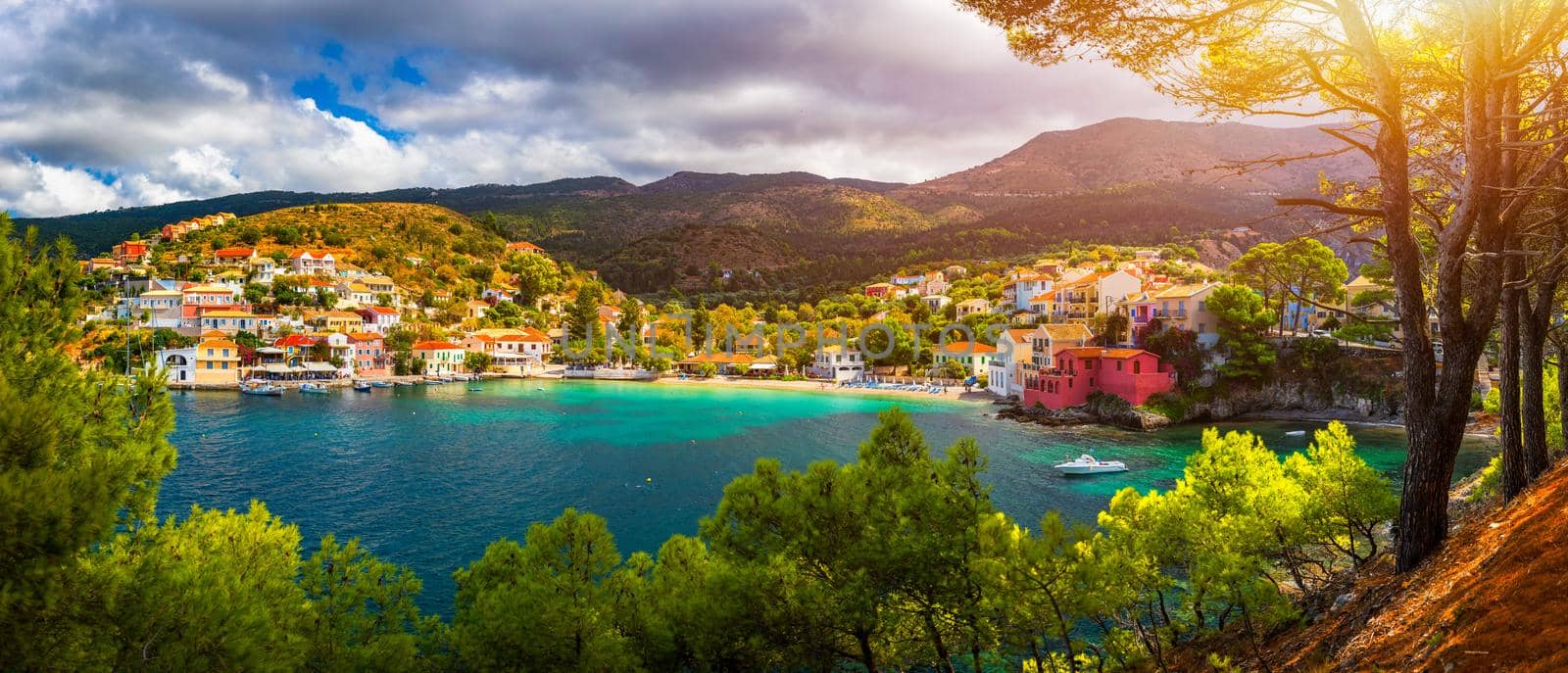 Turquoise colored bay in Mediterranean sea with beautiful colorful houses in Assos village in Kefalonia, Greece. Town of Assos with colorful houses on the mediterranean sea, Greece. 