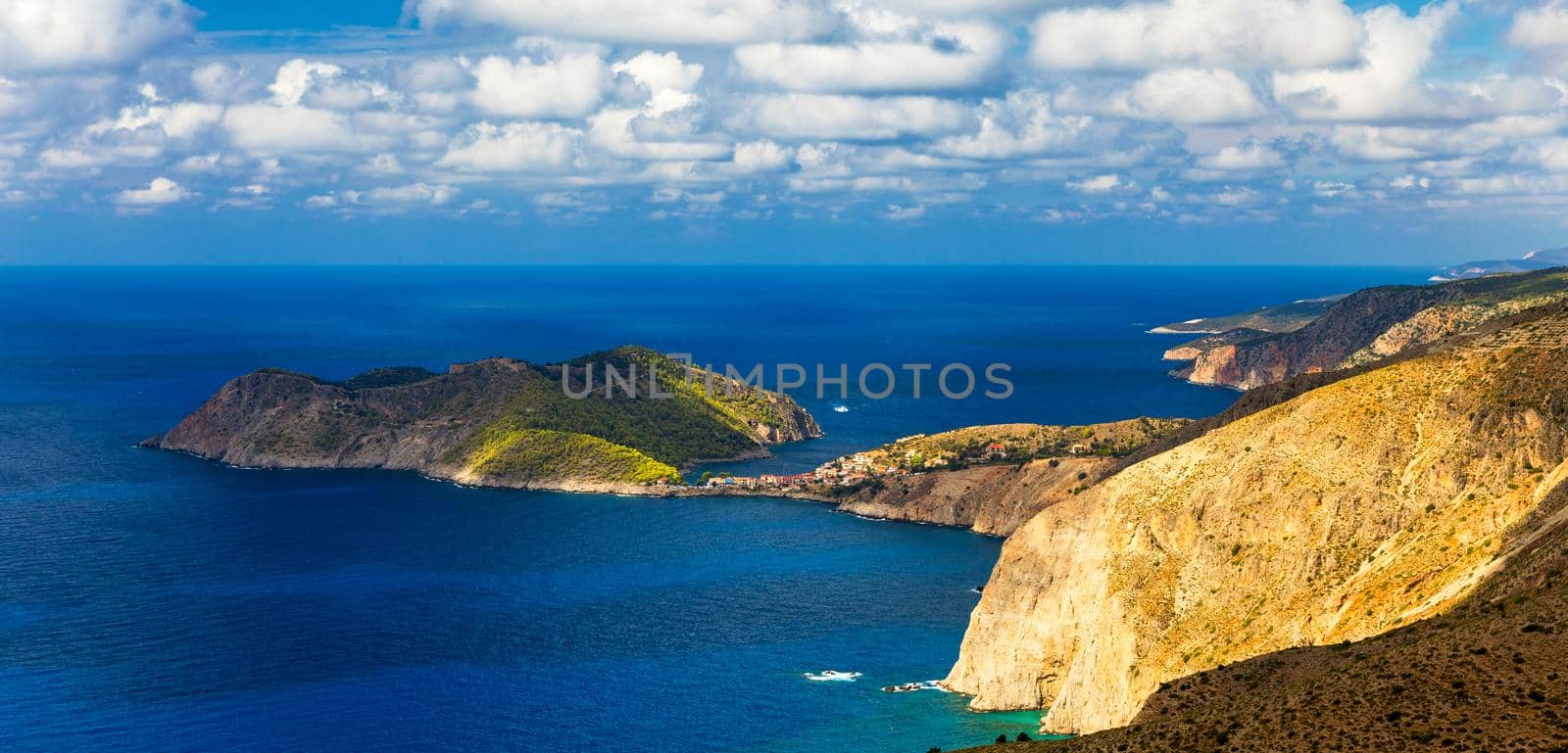 Assos village in Kefalonia, Greece. Turquoise colored bay in Mediterranean sea with beautiful colorful houses in Assos village in Kefalonia, Greece, Ionian island, Cephalonia, Assos village.