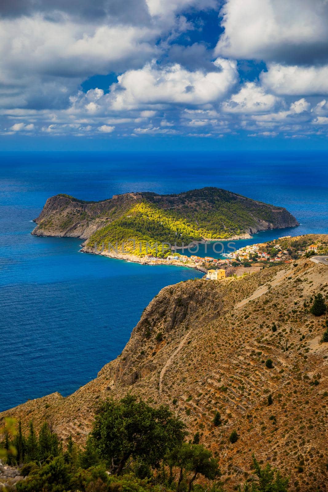 Assos village in Kefalonia, Greece. Turquoise colored bay in Mediterranean sea with beautiful colorful houses in Assos village in Kefalonia, Greece, Ionian island, Cephalonia, Assos village.