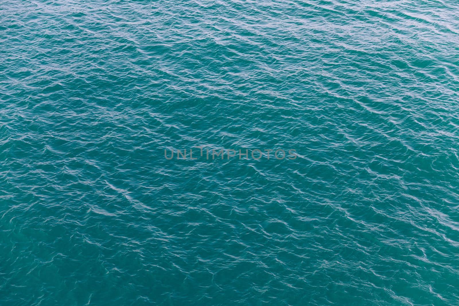 Background shot of aqua sea water surface. Sea surface aerial view. Waving water surface of the sea background.