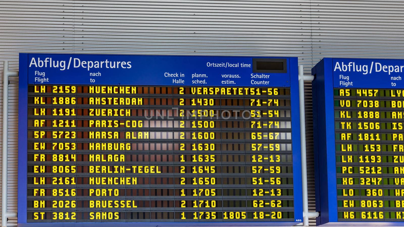 Airport flight information displayed on departure board, flight status changing. Flight schedule screen at airport showing different destinations. 