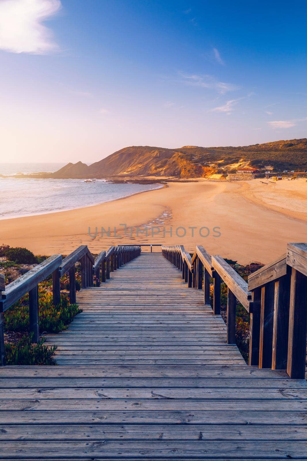 Wooden walkway to the beach Praia da Amoreira, District Aljezur, Algarve Portugal. Panorama from Amoreira beach in the Algarve Portugal. Beach and estuary of the Aljezur river, Praia da Amoreira.